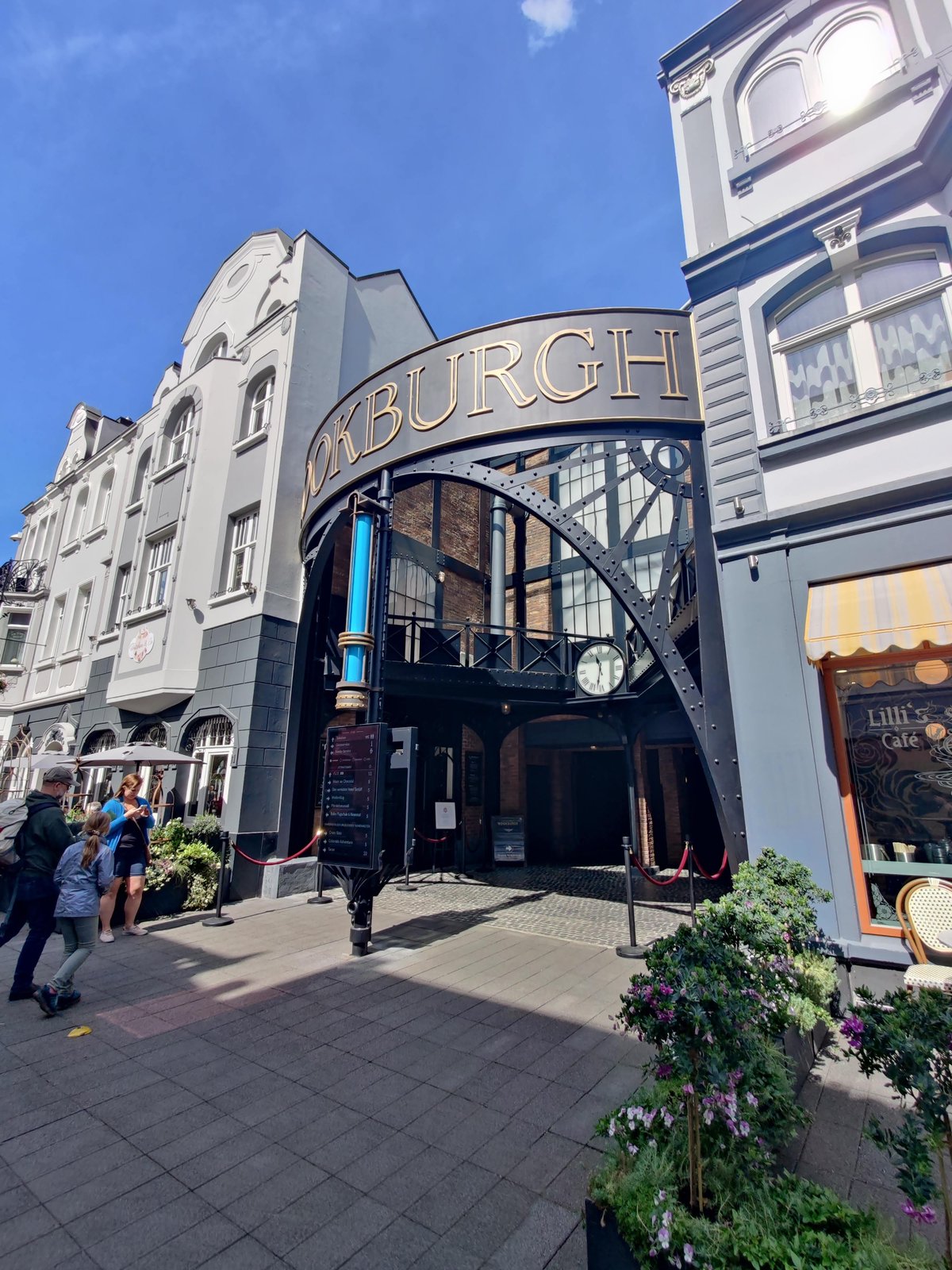 De entree van het Rookburgh gebied. De stalen boog met klok tussen Berlin en Rookburgh, met Lilli's Café rechts en een infozuil met wachttijden. Rookburgh opende in 2020 samen met hotel Charles Lindbergh.