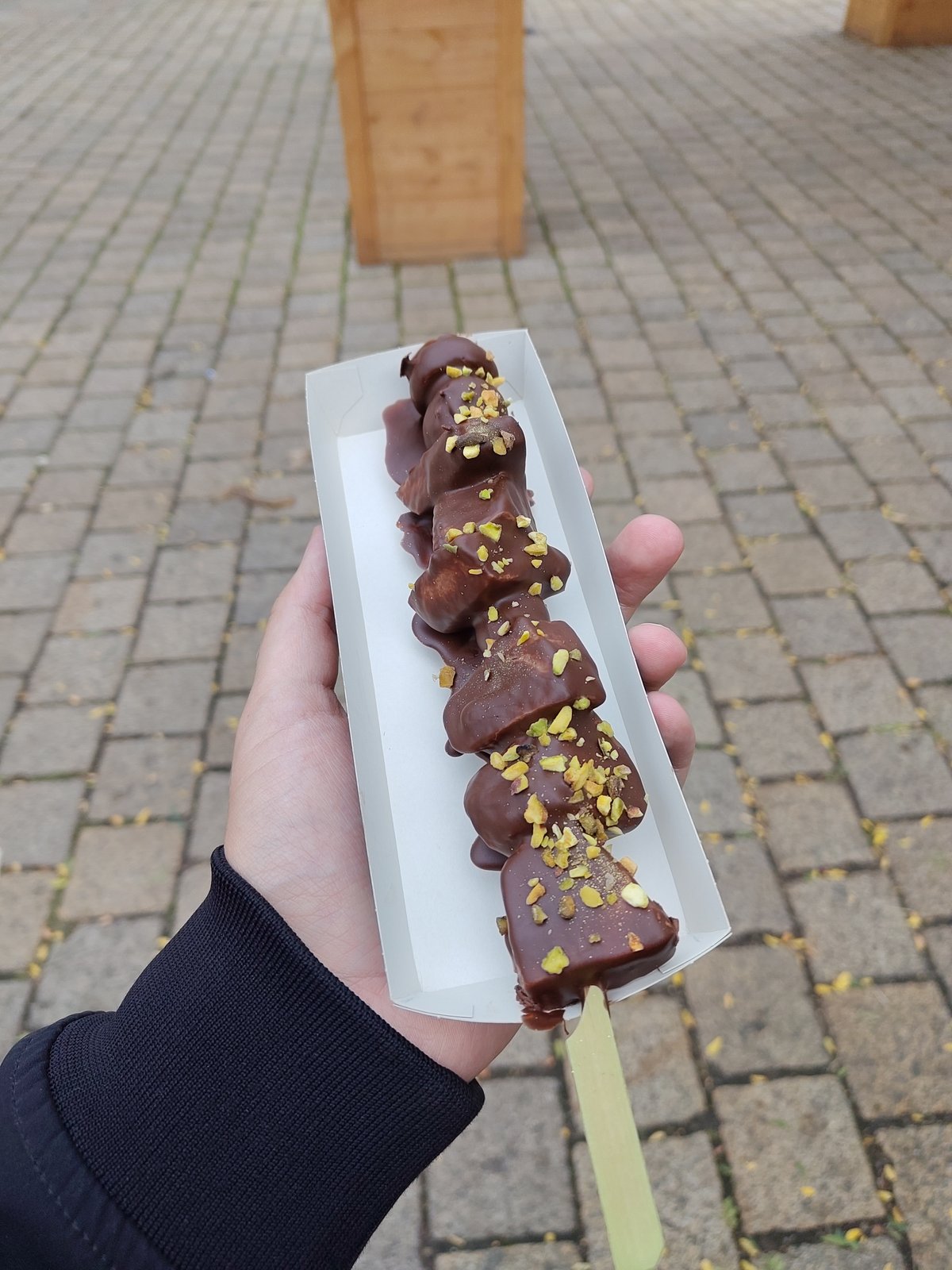 De special van het Fata Morgana plein. Een spies met fruit, omhuld met chocolade en stukjes pistache.