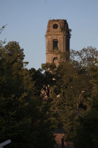 De ondergaande zon schijnt tegen de adijtoren aan.